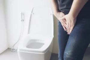 Woman holding hand near toilet bowl - health problem concept. Forrás: jcomp / Freepik