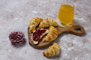 Fresh tasty homemade croissants with raspberry jam on grey-white, french pastry. Fotó: azerbaijan_stockers / freepik